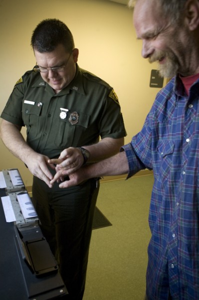 Sgt. M.A. Smith fingerprints Mike Roselle, April 2, 2009, in Beckley, WV.